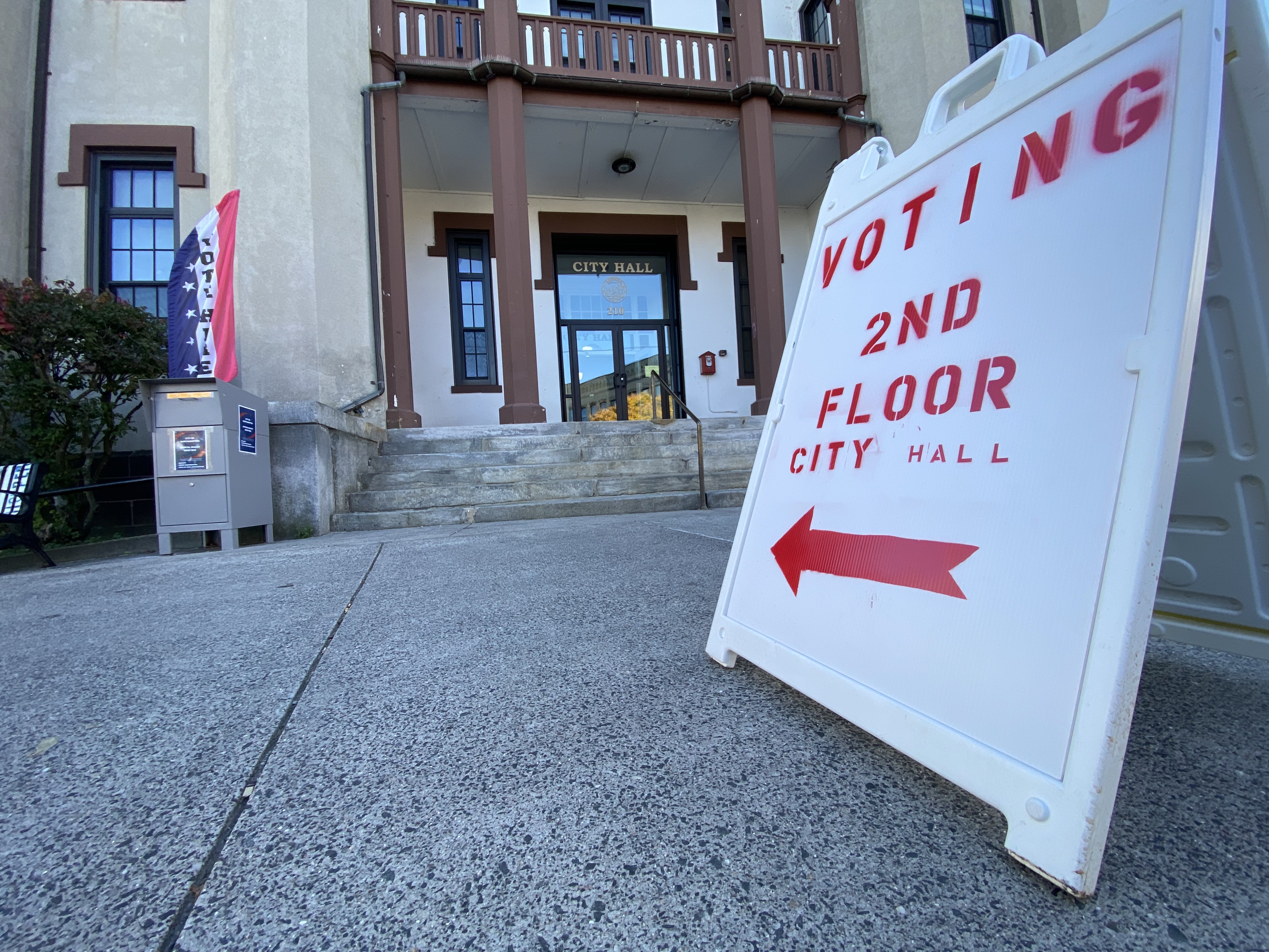 A white, a-frame sign sits in front of Northampton City Hall, a red arrow pointing to the building. "Voting 2nd floor City Hall" it reads.